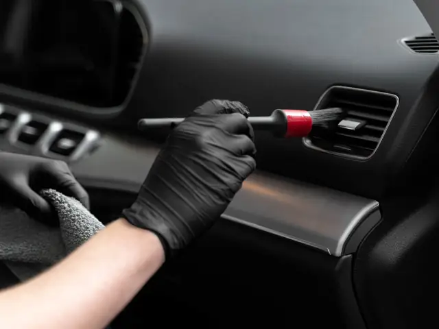 Brushing dust out of a dashboard air vent