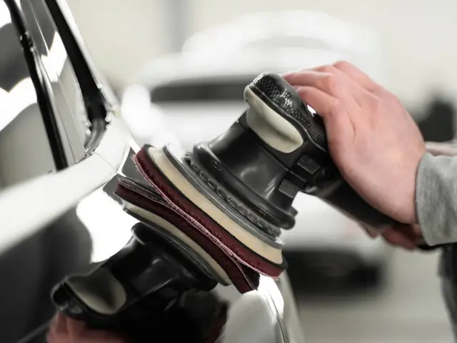 Machine polishing a white car